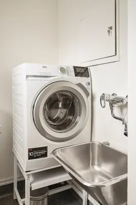 a washing machine in a kitchen with a sink at Trolltunga Fjord Living in Tysso