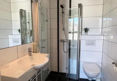 a bathroom with a sink and a shower at Jibben Hotell in Måløy