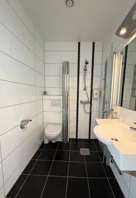 a bathroom with a toilet and a sink at Jibben Hotell in Måløy