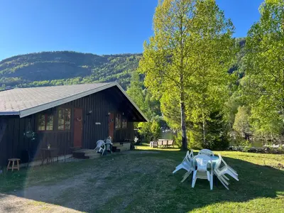 a house with a table and chairs in the yard at Newly renovated cabin near Ål city center, mountains & ski resort in Liagardane