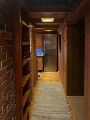 a hallway with a brick wall and a refrigerator at 70S Architectural Cabin With Views In Hemsedal in Hemsedal