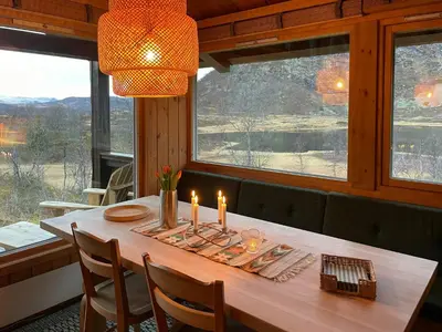 a dining room with a table with candles on it at 70S Architectural Cabin With Views In Hemsedal in Hemsedal