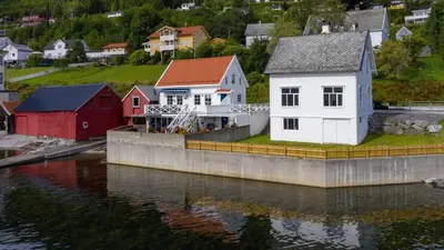 a group of houses next to a body of water at Sjøhuset Sjøholt in Sjøholt