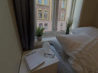 a bedroom with a bed and a desk and a window at Bergen City Center Apartment in Bergen