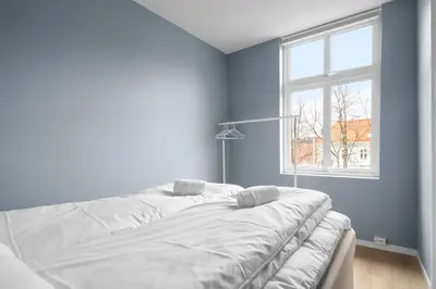 a white bed in a blue room with a window at Bergen Beds Apartments I Nordic Retreat in Bergen