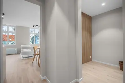 a living room with white walls and a table and chairs at Bergen Beds Apartments I Nordic Retreat in Bergen