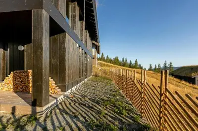 a fence next to a building next to a field at Modern Cabin With Ski In Out At Kvitfjell in Favang