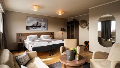 a bedroom with a bed and a living room at Ågotnes Hotell in Ågotnes