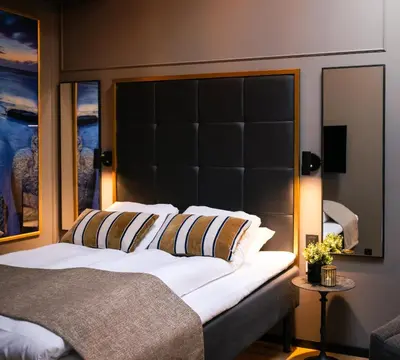 a bedroom with a large bed with a black headboard at Ågotnes Hotell in Ågotnes