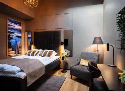 a bedroom with a bed and a chair at Ågotnes Hotell in Ågotnes