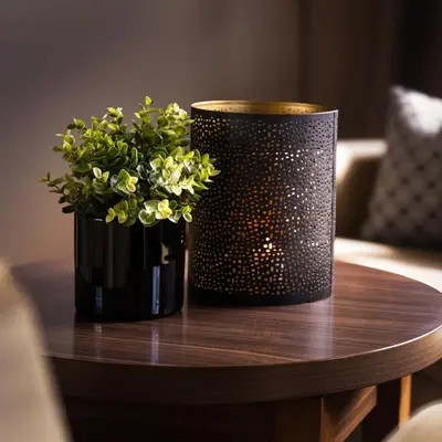 a table with a black vase with flowers on it at Ågotnes Hotell in Ågotnes
