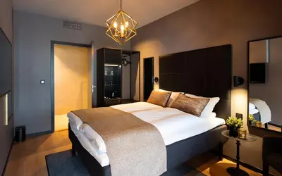 a bedroom with a large bed and a chandelier at Ågotnes Hotell in Ågotnes
