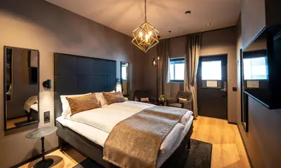 a bedroom with a large bed and a chandelier at Ågotnes Hotell in Ågotnes