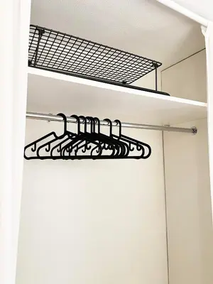 a black metal shelf in a white closet at Du vil elske å bo her! Et lite, men koselig sted med perfekt beliggenhet! in Trondheim