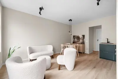 a living room with white chairs and a table at Bergen Beds Apartments I Urban Escape in Bergen
