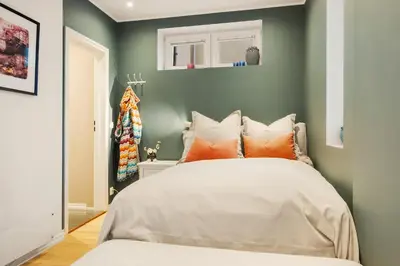 a bedroom with a white bed with orange pillows at Luxury Summer Apartment with Balcony Near Bryggen in Bergen