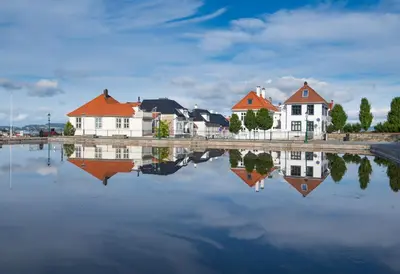 a group of houses are reflected in a body of water at Luxury Summer Apartment with Balcony Near Bryggen in Bergen