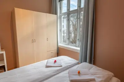 a bedroom with a bed with towels and a window at Roomsly Apartments - Prime Location and Modern Comfort in Bergen