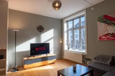a living room with a tv and a couch at Roomsly Apartments - Prime Location and Modern Comfort in Bergen