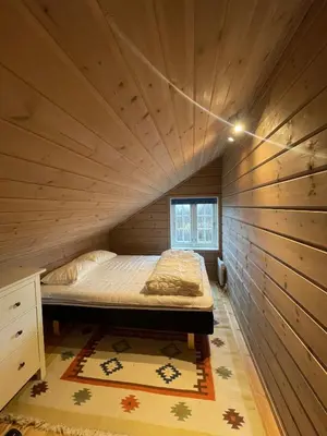 a bed in a small room with a wooden ceiling at Cottage in scenic surroundings in Hol