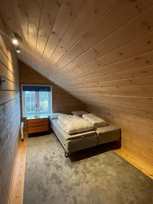 a bed in a wooden room with a window at Cottage in scenic surroundings in Hol