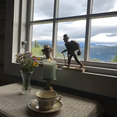 a table with a candle and a statue in a window at Charming lodge from 1888 in Sel