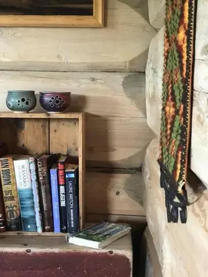 a book shelf with books on it next to a wall at Charming lodge from 1888 in Sel