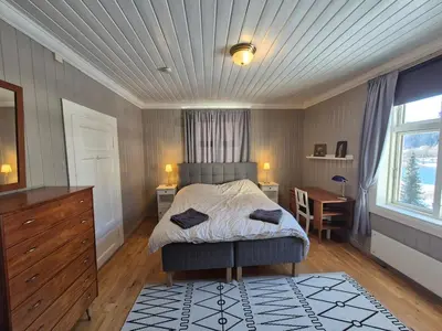 a bedroom with a bed and a desk and a window at Large Family Friendly Apartment in Lillehammer