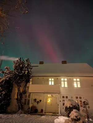 a white building with a rainbow in the sky at Large Family Friendly Apartment in Lillehammer