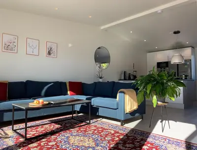 a living room with a blue couch and a table at Elegant Townhouse, Breathtaking Views and Free Parking in Ålesund