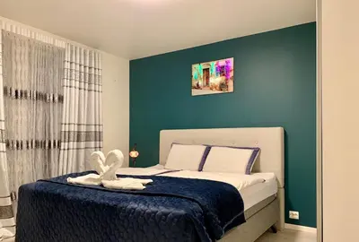 a bedroom with a bed with a blue wall at Elegant Townhouse, Breathtaking Views and Free Parking in Ålesund