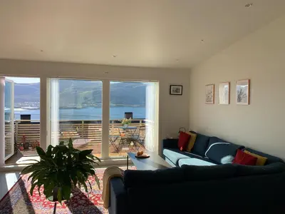 a living room with a couch and a large window at Elegant Townhouse, Breathtaking Views and Free Parking in Ålesund