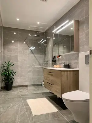 a bathroom with a toilet and a sink and a shower at Elegant Townhouse, Breathtaking Views and Free Parking in Ålesund