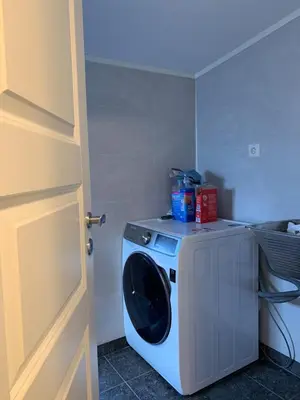 a washing machine in a room with a door at Elegant Townhouse, Breathtaking Views and Free Parking in Ålesund