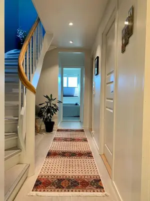 a hallway with a rug on the floor at Elegant Townhouse, Breathtaking Views and Free Parking in Ålesund