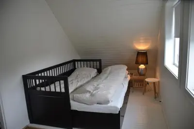 a small bed in a room with a window at House with all amenities for rent in Steinkjer