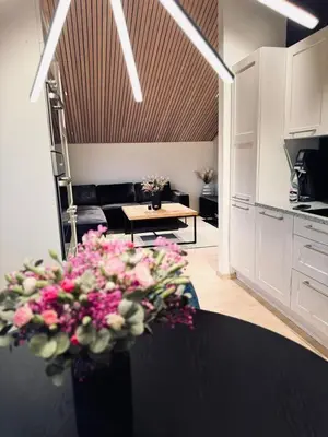 a kitchen and a living room with a table with flowers at Cozy Apartment in Melhus in Melhus