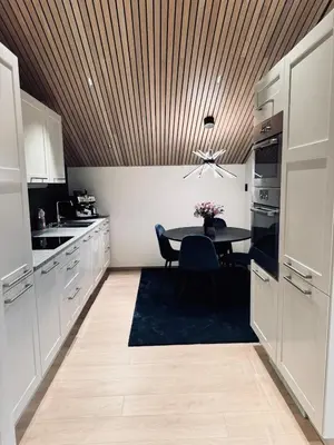 a kitchen with a dining table and a wooden ceiling at Cozy Apartment in Melhus in Melhus