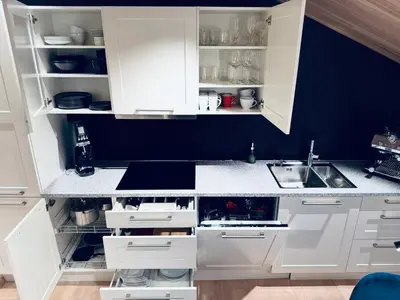 a white kitchen with white cabinets and a sink at Cozy Apartment in Melhus in Melhus