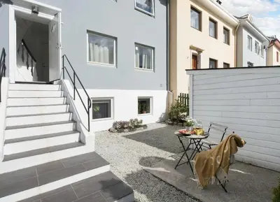 a courtyard with a table and stairs in a house at Cozy apartment near city center and the mountains in Bergen