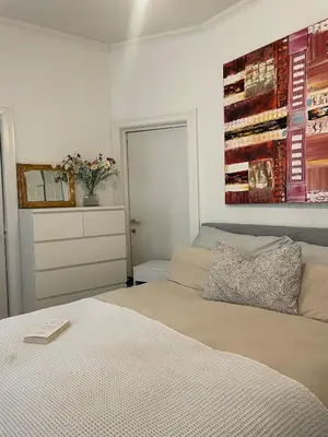 a bedroom with two beds and a painting on the wall at Modern and Cosy apartment in Bergen City Centre in Bergen