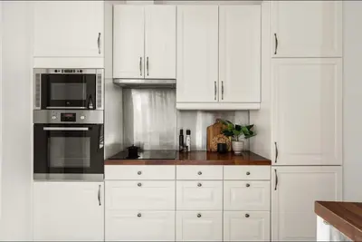 a kitchen with white cabinets and a stove top oven at Modern and Cosy apartment in Bergen City Centre in Bergen