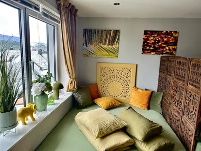 a living room with a couch and a window at Stylish free parking Studio central with balcony in Ålesund