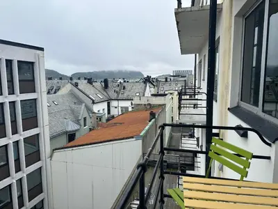 a balcony with chairs and a view of a city at Stylish free parking Studio central with balcony in Ålesund