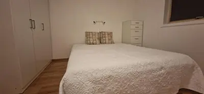 a small bedroom with a bed and a dresser at Cozy flat in the heart of Bergen in Bergen