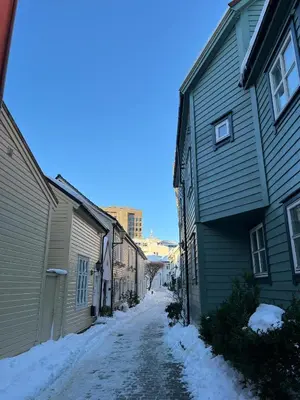 a snow covered alley way between two buildings at Cozy flat in the heart of Bergen in Bergen
