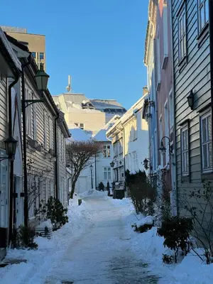 a snow covered street in a city with buildings at Cozy flat in the heart of Bergen in Bergen
