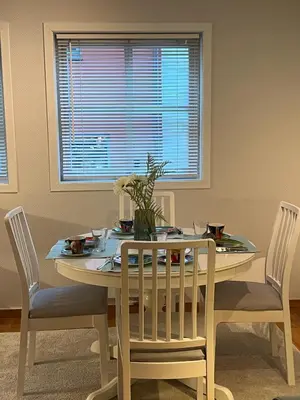 a dining room with a table and chairs and a window at Cozy flat in the heart of Bergen in Bergen