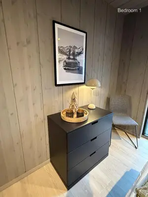 a black dresser in a room with a picture on the wall at The Panoramic Chalet in Stranda