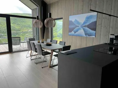 a kitchen and dining room with a table and chairs at The Panoramic Chalet in Stranda